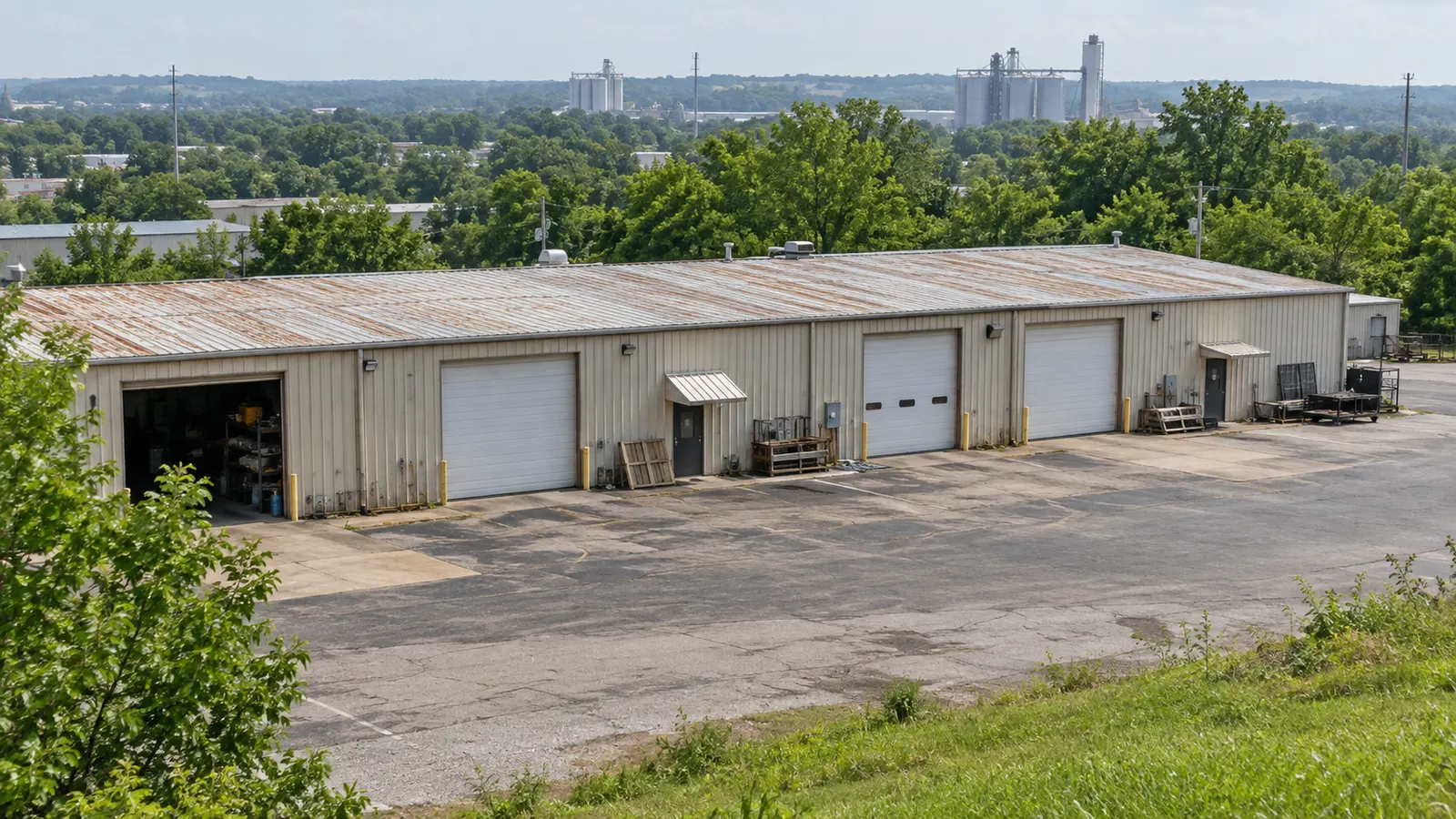 Single-story commercial metal building with roll-up doors and a paved lot